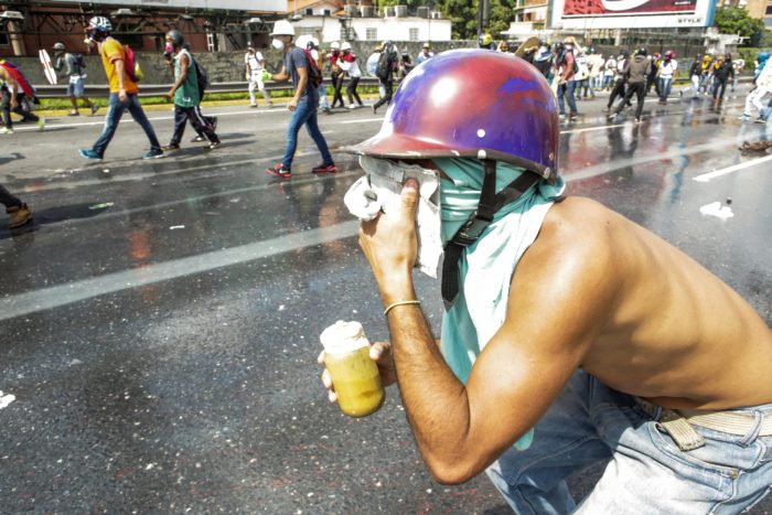CAR47. CARACAS (VENEZUELA), 10/05/2017 - Un manifestante arroja una bomba de heces a a la Guardia Nacional Bolivariana hoy, miércoles 10 de mayo de 2017, en Caracas (Venezuela). Los manifestantes que desde hace más de un mes han salido a las calles de Venezuela para protestar en contra del Gobierno de Nicolás Maduro, han encontrado otra forma de afrontar a los funcionarios de seguridad al lanzarles tarros de excremento, que hoy se conocen como "puputov". EFE/CRISTIAN HERNÁNDEZ