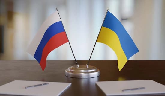 El expansionismo de la OTAN y la operación militar de Rusia en Ucrania 1 Las banderas de Rusia y Ucrania sobre la mesa en signo de negociación
